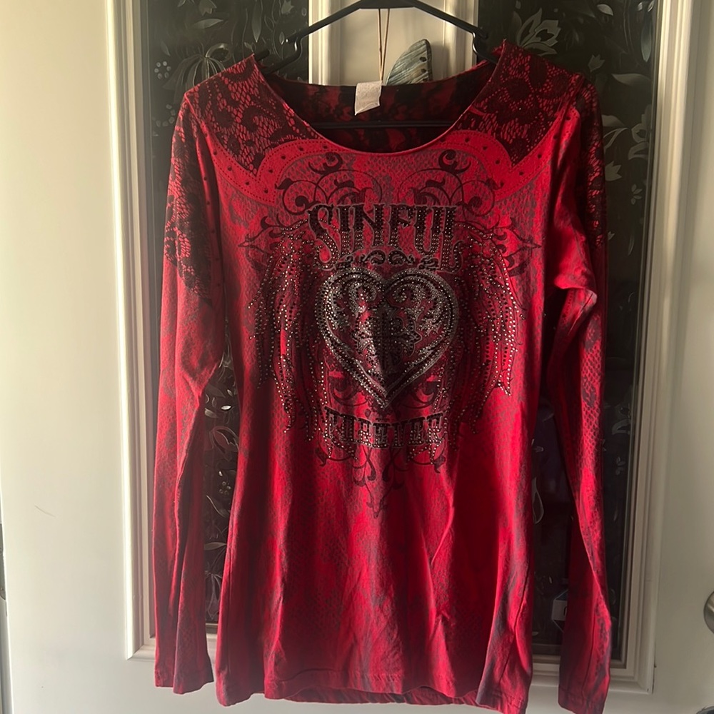 Women’s long sleeve Sinful top with black lace back.